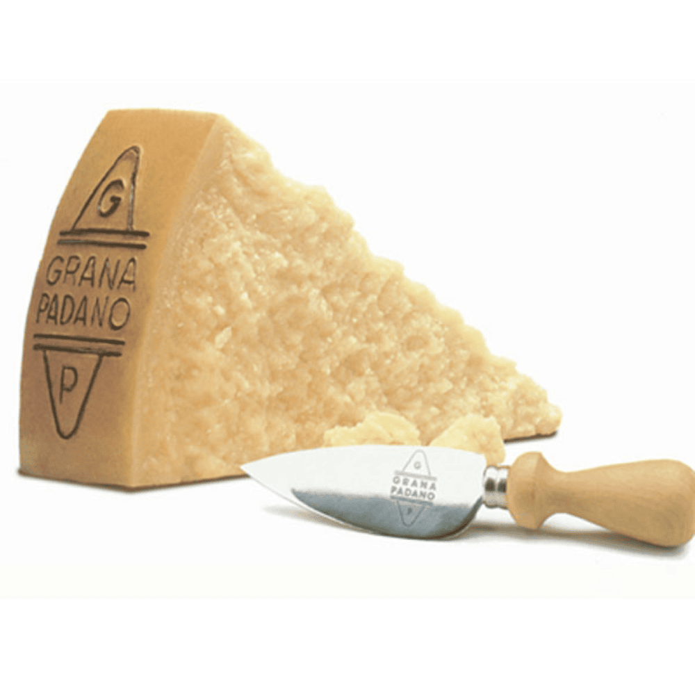 Grana Padano cheese wedge with a cheese knife on a white background