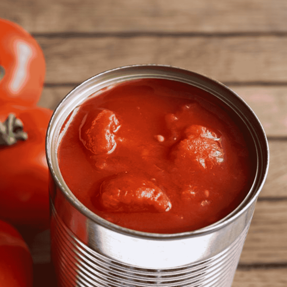 Can of san marzano tomato sauce with a whole tomato on a wooden surface