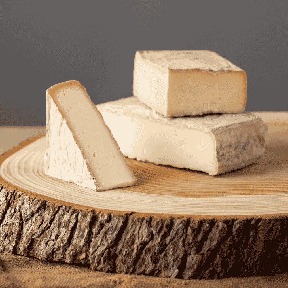 taleggio italian cheese on a wooden board with a rustic background
