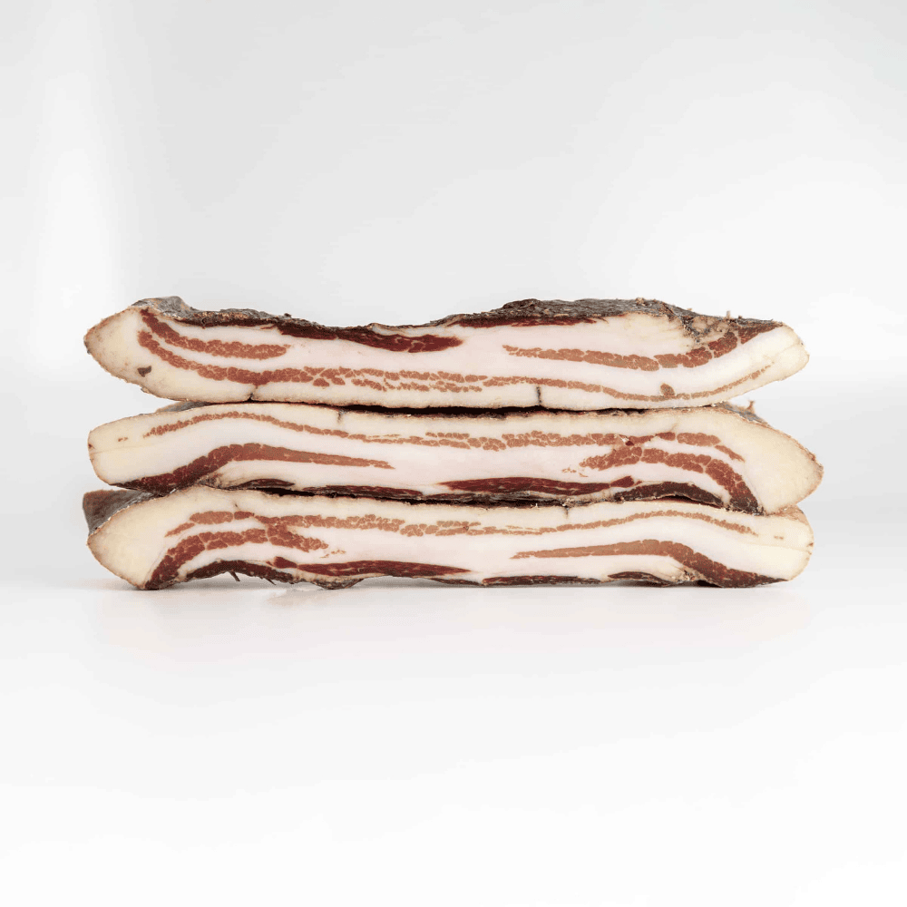 whole pancetta tesa pieces on white background