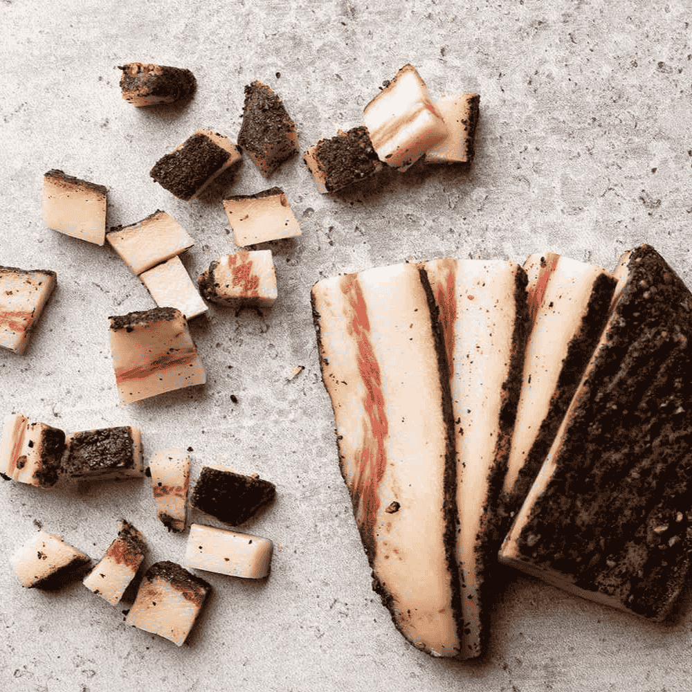 gunaciale with slices and chunks on a textured surface